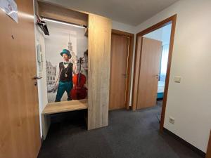 a boy standing in a room with a guitar in a mirror at Gemütliches Apartment mit Blick zur Frauenkirche in Dresden