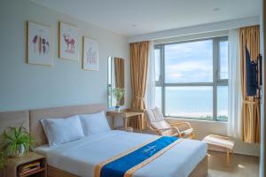 a hotel room with a bed and a large window at Lucky House - Second Home in The Sóng Vũng Tàu in Vung Tau