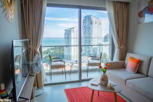 a living room with a couch and a large window at Lucky House - Second Home in The Sóng Vũng Tàu in Vung Tau