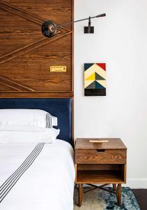 a bedroom with a bed and a wooden headboard at Thompson Nashville in Nashville