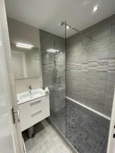 a bathroom with a shower and a sink and a glass shower stall at Vue Lac, Central et Contemporain in Évian-les-Bains