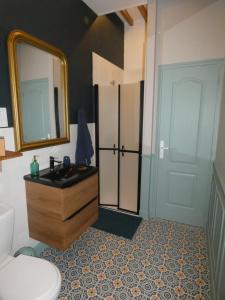 een badkamer met een wastafel, een toilet en een spiegel bij Gîte de la Ferme Feugère in Barbeville +35 foto's