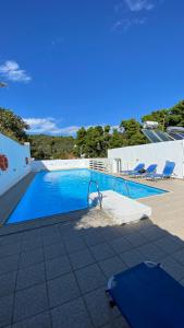 a large swimming pool with chairs next to it at Galini Hellenic Hospitality in Patitiri