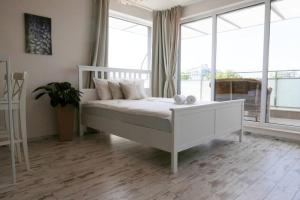 a white bed in a room with windows at Charmful new flat with Hill view in Plovdiv