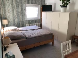 Schlafzimmer mit einem Bett und einem Fenster in der Unterkunft Stadtvilla-Apartment mit Parkblick und bester Verkehrsanbindung in Bremerhaven