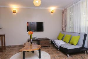 uma sala de estar com um sofá e uma televisão em PachobyDaisy em Awasi