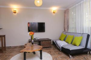 a living room with a couch and a tv at PachobyDaisy in Awasi