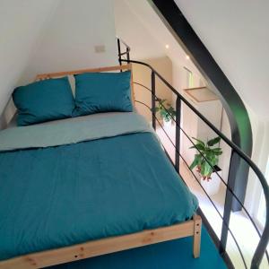 uma cama com almofadas azuis numa escada em Stijlvolle ruimte in historische boerderij. em Destelbergen
