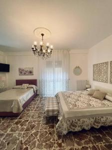 a bedroom with two beds and a chandelier at Il Piccolo Attico 2 in Caltagirone