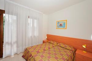 a bedroom with a bed and a window at Beautiful Two-Bedroom Villa in Bibione - Beahost in Bibione