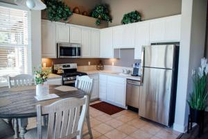 a kitchen with a table and a stainless steel refrigerator at Gateway Hotel, Trademark Collection by Wyndham in Copper Cove Subdivision