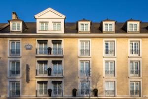 un gran edificio de ladrillo con ventanas en Best Western Royal Hotel Caen en Caen