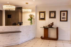 a lobby with a counter with a statue on it at Best Western Royal Hotel Caen in Caen