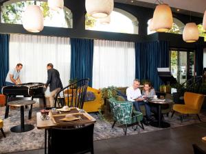 a group of people sitting at tables in a restaurant at Aparthotel Adagio Lyon Patio Confluence in Lyon