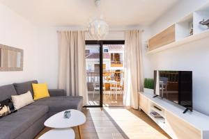 a living room with a couch and a tv at Home2Book Cardón Sunny Design Home Los Cristianos in Arona