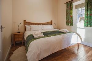 1 dormitorio con cama y ventana en Castle Cottage, a self-catering cottage full of character., en Amhuinnsuidhe