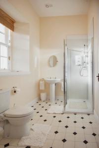 Baño blanco con aseo y lavamanos en Castle Cottage, a self-catering cottage full of character., en Amhuinnsuidhe