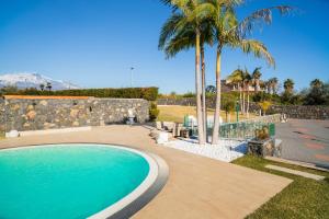 a swimming pool in a yard with palm trees at VILLA PARADISO ACIREALE "con piscina in esclusiva o condivisa " in Acireale