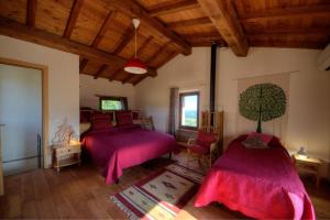 Duas camas num quarto com tectos em madeira em agriturismo Poggio Monte Saturnia em Saturnia