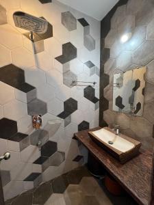 a bathroom with a sink and a tiled wall at iIRA Stays-Sea Coast Farm in Alibaug