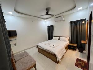 ein Schlafzimmer mit einem Bett und einem TV. in der Unterkunft iIRA Stays-Sea Coast Farm in Alibag