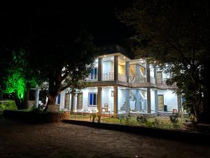 a large white house with a balcony at night at iIRA Stays-Sea Coast Farm in Alibaug