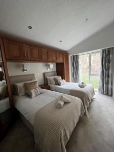 a bedroom with two beds with towels on them at Lowena Lodge in Troutbeck