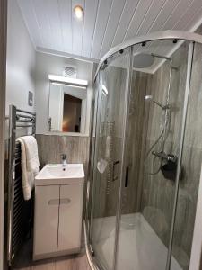 uma casa de banho com um chuveiro e um lavatório. em Lowena Lodge em Troutbeck