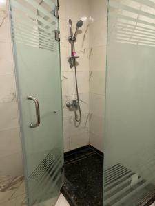 a shower with a glass door in a bathroom at Regency Hotel Alexandria in Alexandria
