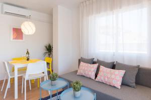 ein Wohnzimmer mit einem Sofa und einem Tisch in der Unterkunft MalagaSuite Pier Fuengirola in Fuengirola