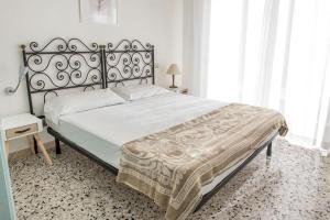 een slaapkamer met een groot bed met een metalen frame bij N122 - Numana, villa singola con giardino e vista mare in Numana