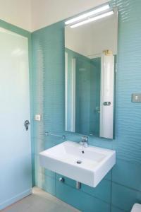 een badkamer met een witte wastafel en een spiegel bij N122 - Numana, villa singola con giardino e vista mare in Numana