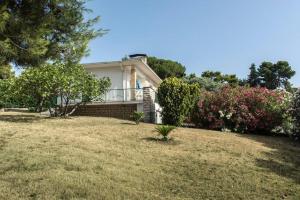 een wit huis met een tuin met bloemen bij N122 - Numana, villa singola con giardino e vista mare in Numana