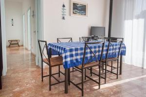 een tafel met stoelen en een blauw en wit tafelkleed bij N122 - Numana, villa singola con giardino e vista mare in Numana