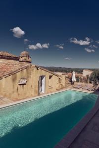 a swimming pool in front of a building at Hotel de L Orange in Sommières