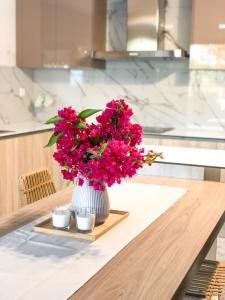 a vase filled with pink flowers sitting on a table at Luxury Villa Anemone with private pool in Pastida