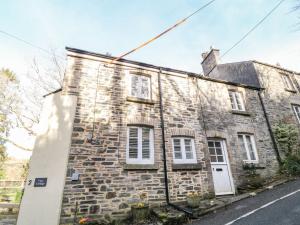 an old stone house with white windows and white doors at Vigo Cottage in Tavistock