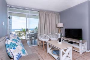 Chaka's Cove في باليتو: غرفة معيشة مع أريكة وتلفزيون