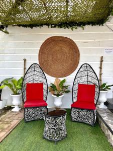 dwa krzesła z czerwonymi poduszkami na patio w obiekcie Little Rock Cebu w mieście Mactan