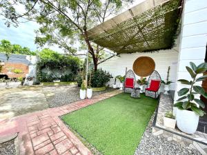 a patio with two chairs and a green lawn at Little Rock Cebu in Mactan