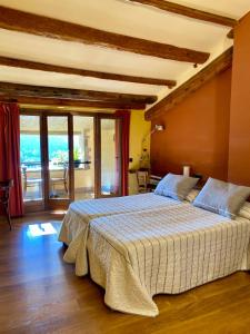 um quarto com uma cama grande e uma varanda em CAMPALANS Hotel Rural Bungalows Mobilhomes em Borredá