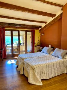 a bedroom with a large bed and a balcony at CAMPALANS Hotel Rural Bungalows Mobilhomes in Borredá