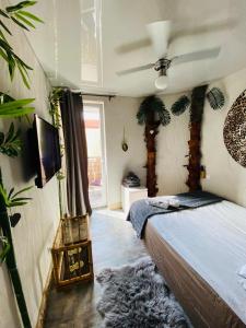 エウクにあるKuredu / Uroa w Krainie Alicjiのベッドルーム(ベッド1台、テレビ、植物付)