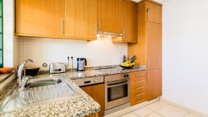 a kitchen with wooden cabinets and a sink at Central Albufeira Great Location 