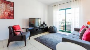 a living room with a couch and a tv at Central Albufeira Great Location 