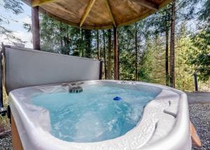 einen Whirlpool in einem Pavillon im Wald in der Unterkunft Bulworthy Forest Lodges in Instow