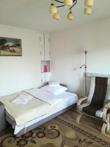1 dormitorio con 1 cama y 1 silla en Apartament Praski 5 minut od metra i starego miasta spacerem do zoo i Konesera en Varsovia