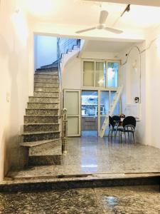 una escalera en una casa con mesa y sillas en Hanoi All Nations Homestay, en Hanói