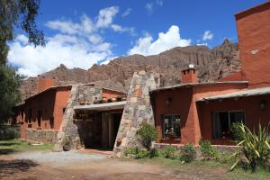 a building with a mountain in the background at Hotel Punta Corral in Tilcara