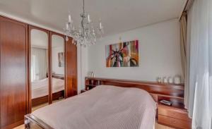 um quarto com uma cama e um lustre em Huis Kleur em Grubbenvorst